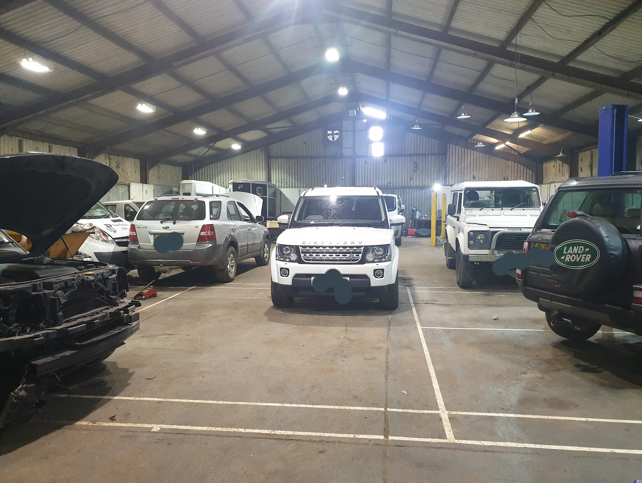 Inside the big workshop shed: a Discovery 4, a Defender and other vehicles in for work